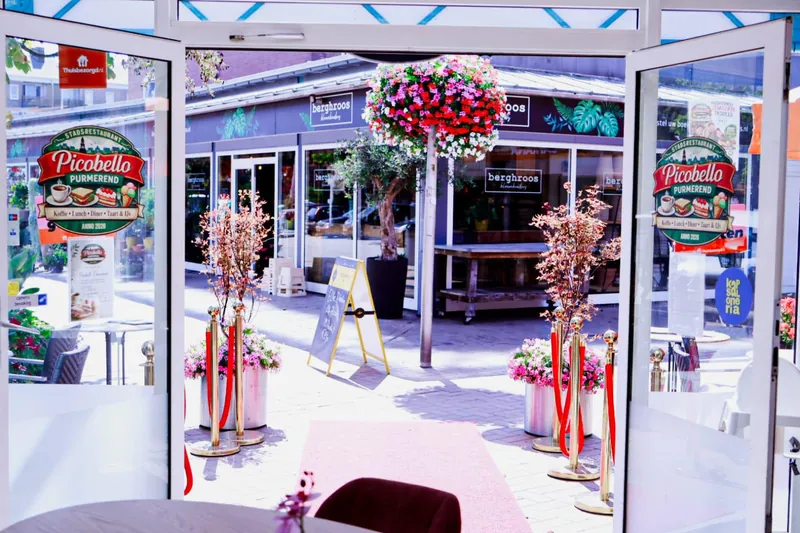 De ingang met terras en bloemen