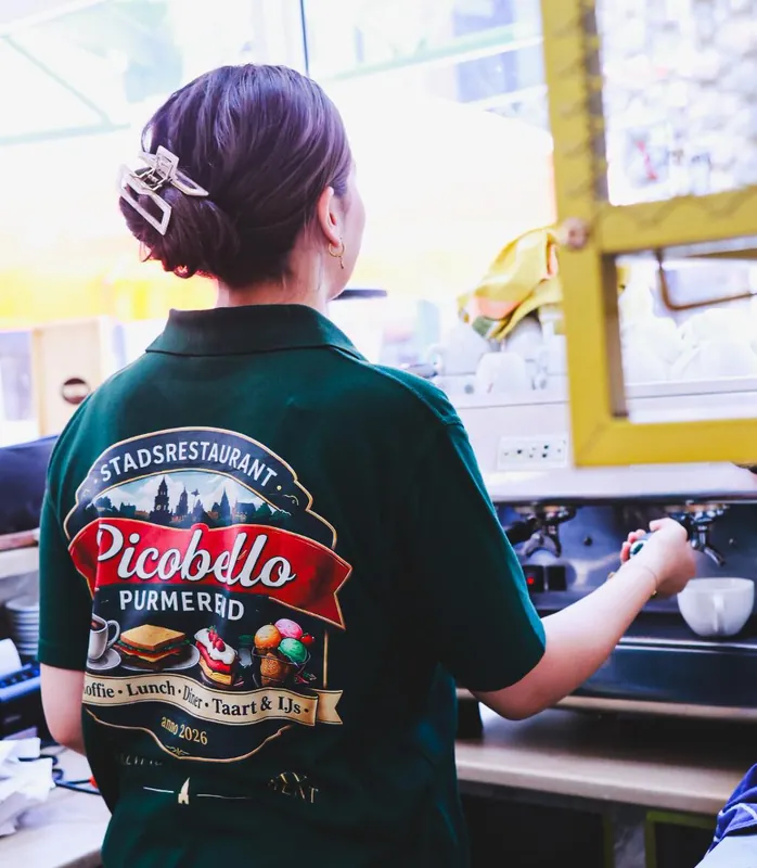 Een medewerker in Picobello-polo achter de bar