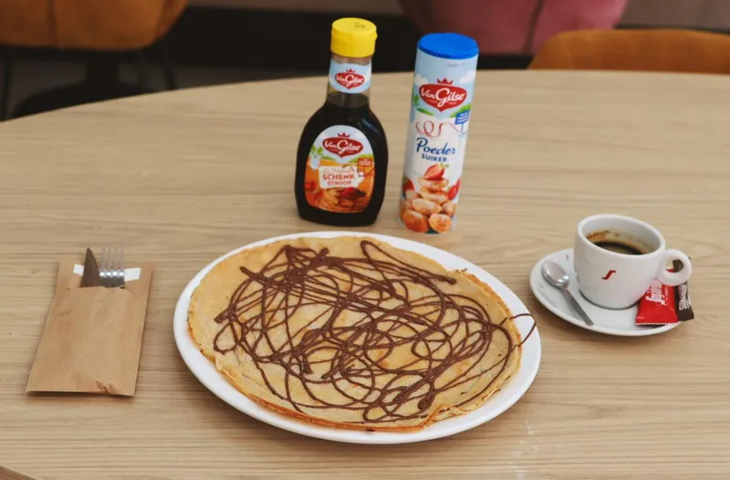 Pannenkoek met chocoladesaus en een kop koffie