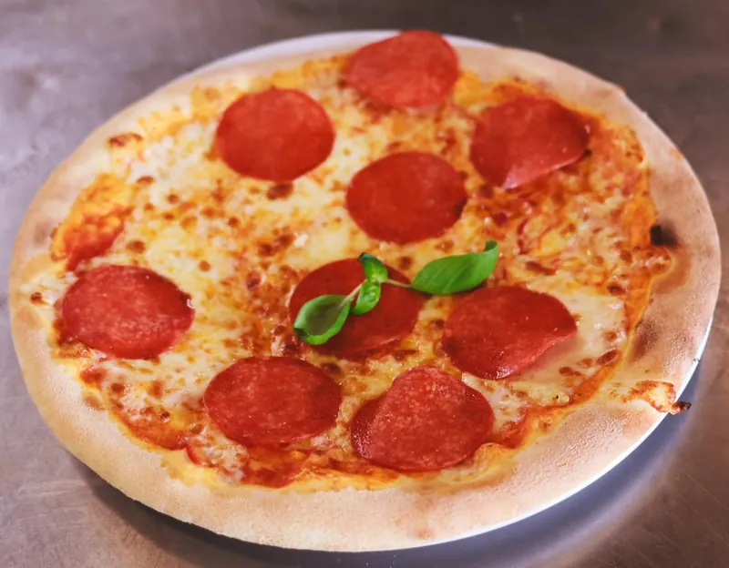 Pizza pepperoni met verse basilicum
