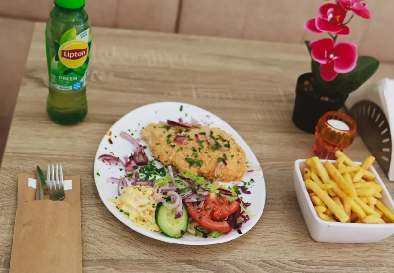 Schnitzel met salade, rode ui en friet