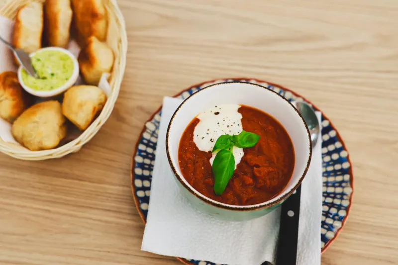 Tomatensoep met een toef room en verse basilicum